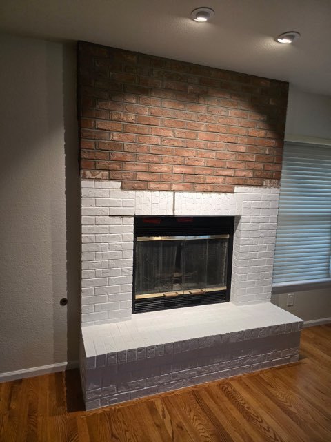 Brick fireplace refinished in crisp white paint