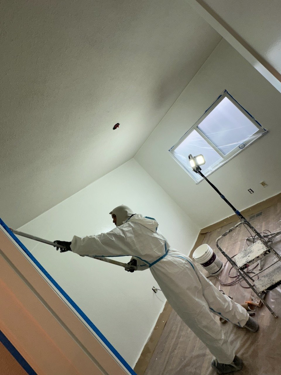 Carlos Drywall and Paint crew spray finishing a vaulted ceiling